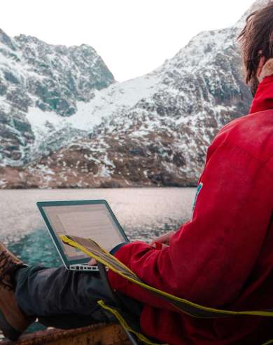 A man working outdoors by the sea at the Arctic Coworking Lodge in Lofoten, Northern Noway