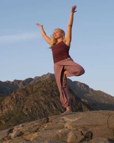A woman doing yoga while on a hike in Lofoten, Northern Norway