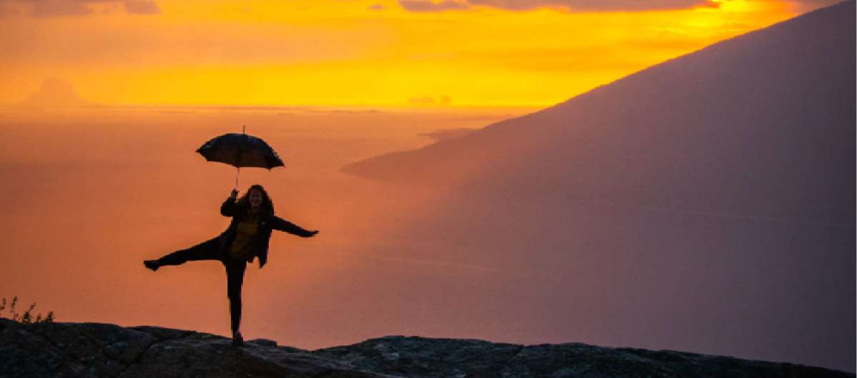 Girl holding an umbrella at the Sjonfjellet mountain in Northern Norway