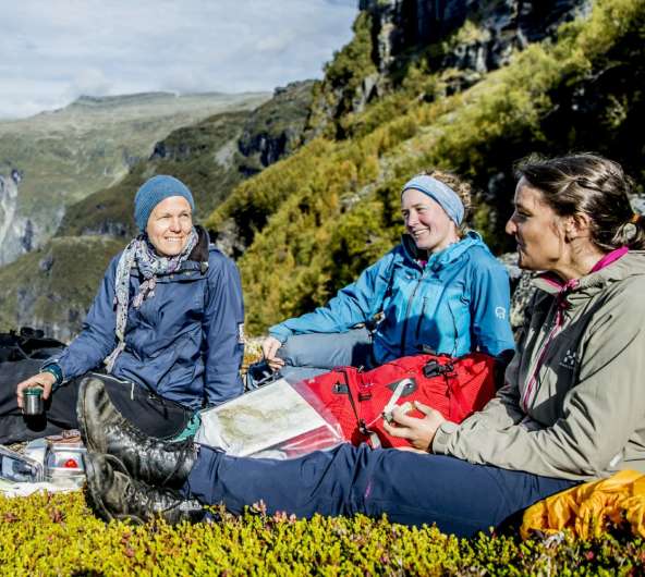 Plan your trip to Norway. People with maps resting in the Aurlandsdalen valley