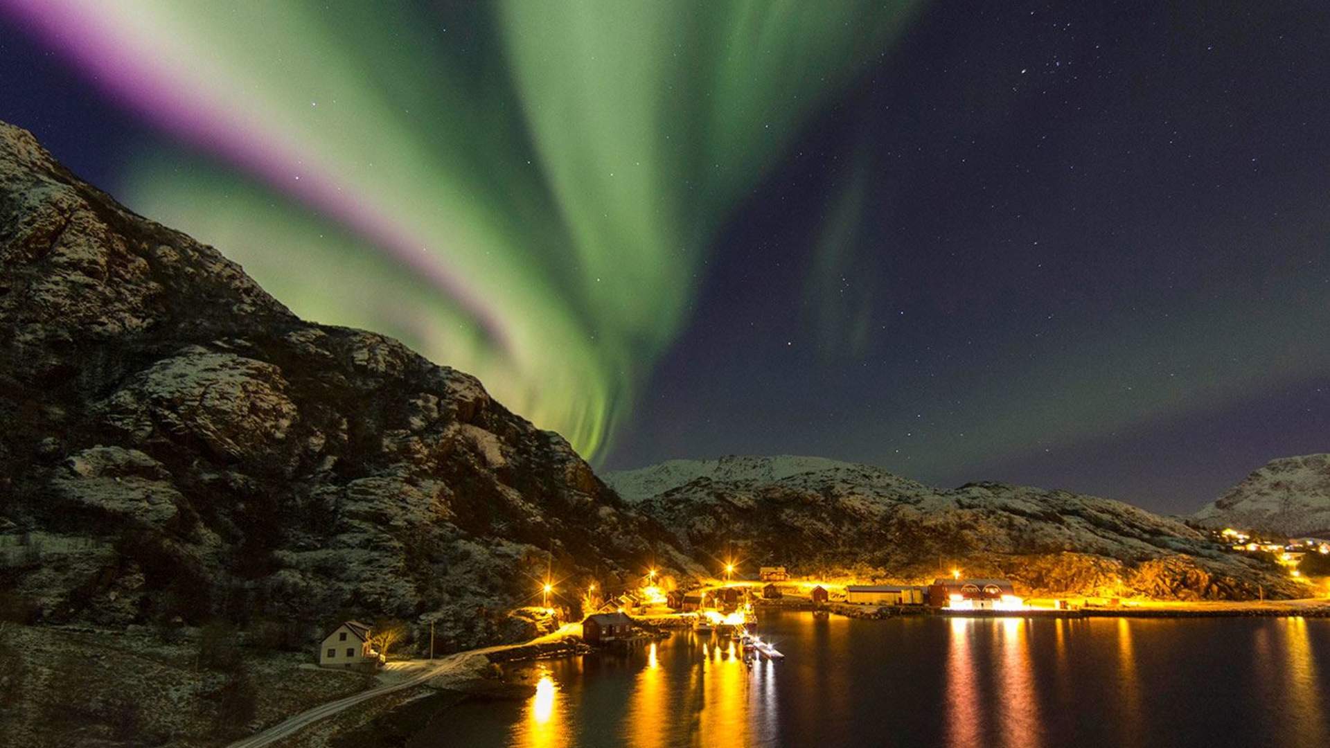Northern light above fjord and Vesterålen fisherman's cabins