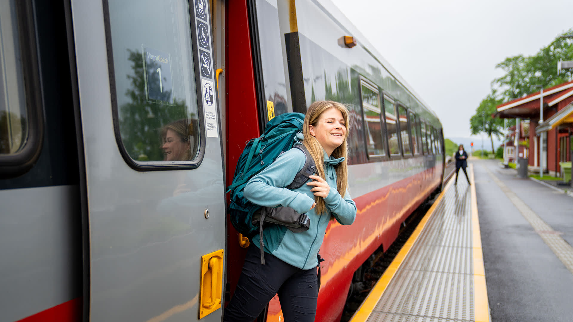 A woman exiting a train at Røra station-Fredrik Ahlsen - Maverix