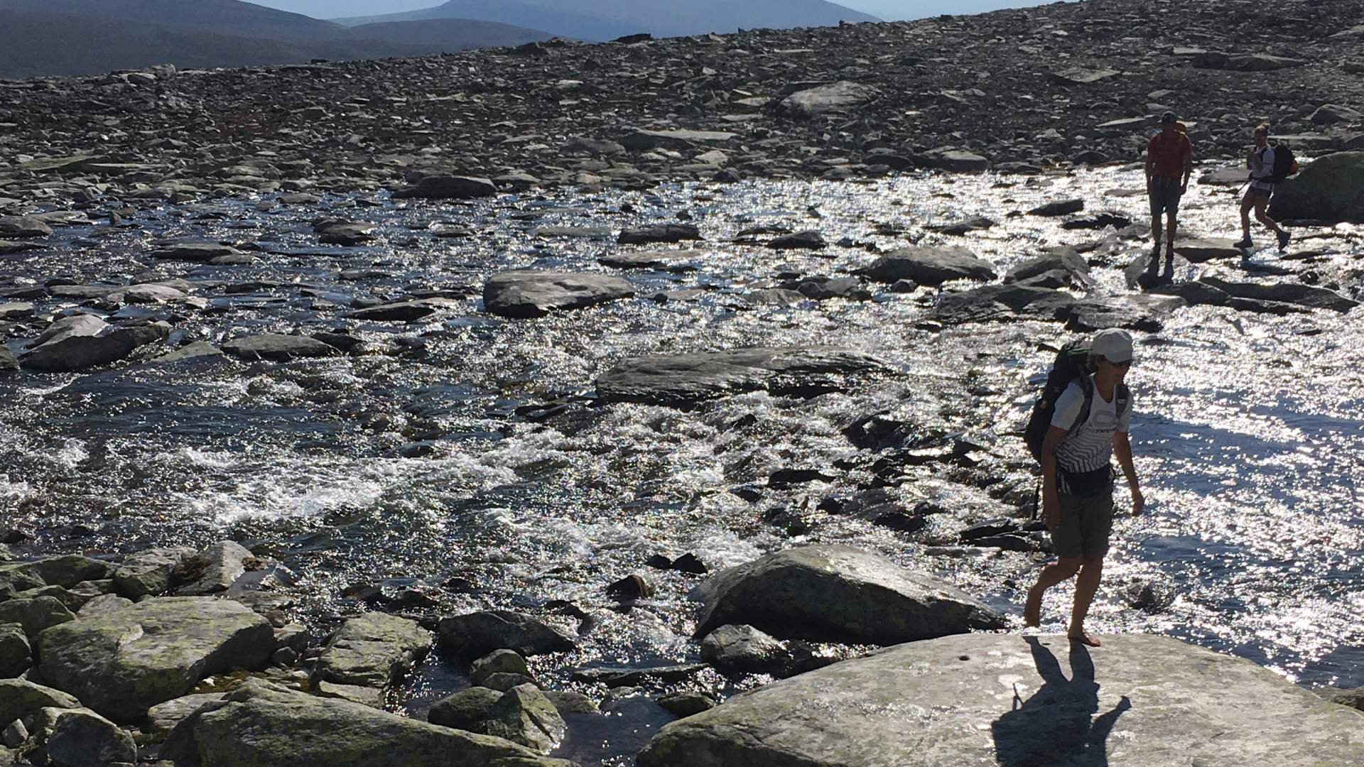 Turgåere krysser rennende vann i fjellet | Venabu Fjellhotell