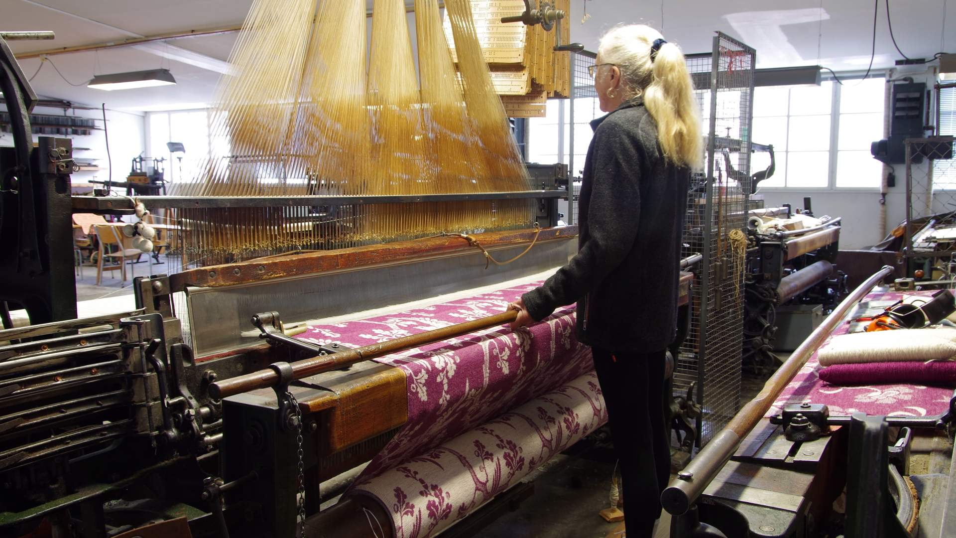 Sjølingstad Uldvarefabrik, Gunnveig Helland ved jacquardvevstolen, foto Arve Lindvig, Vest-Agder-mus