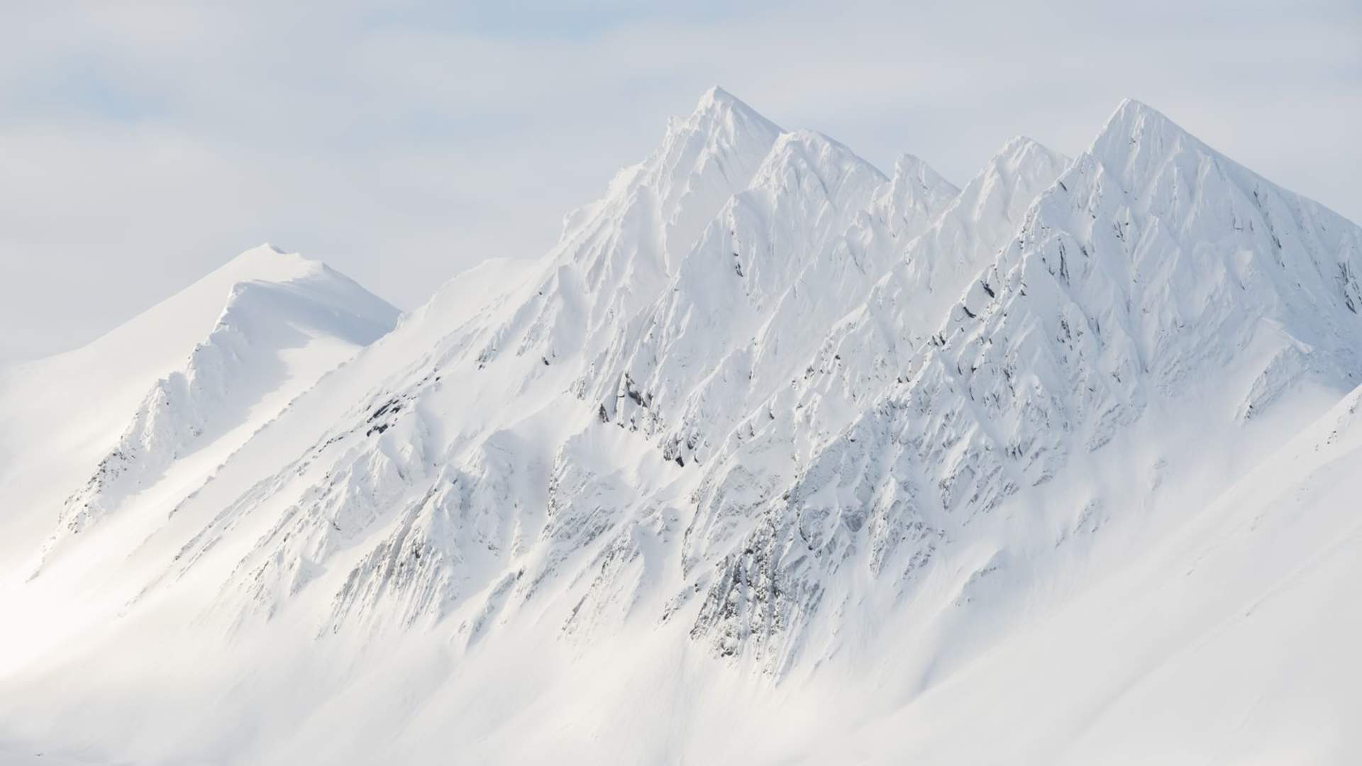snowy-mountain-peaks-under-a-clody-sky