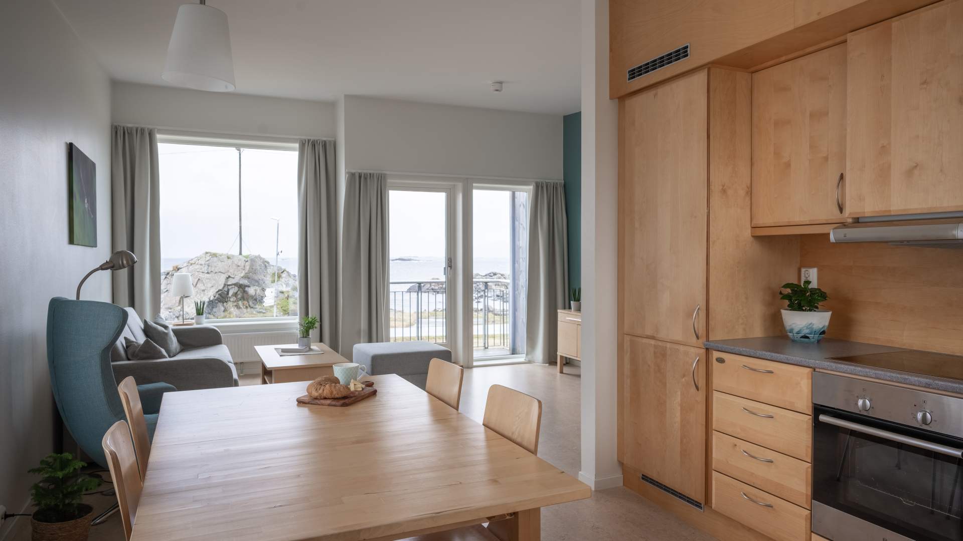 Kjøkken og stue med sitteplasser og arbeidsbord og spisebord