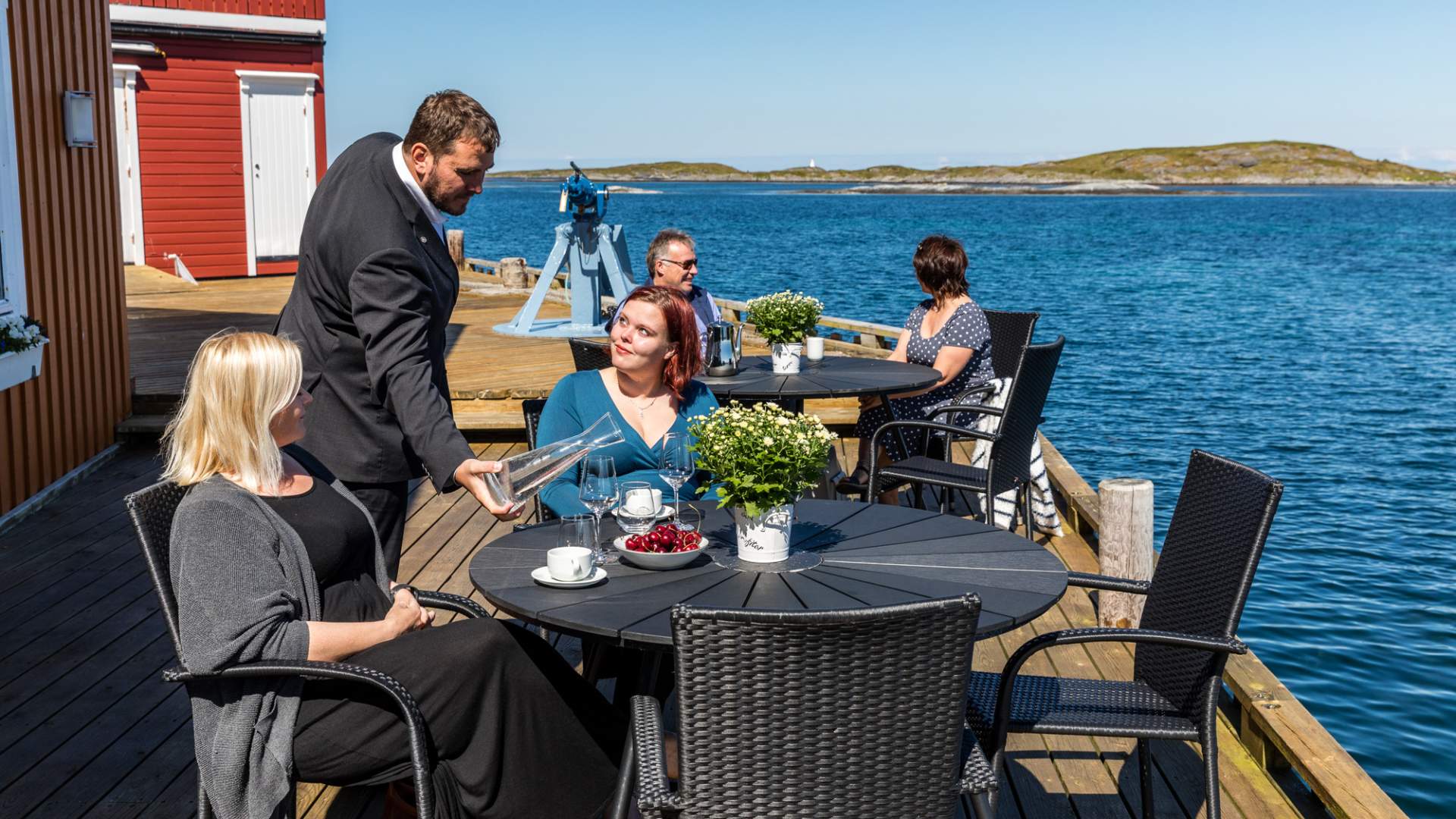 Uteservering på brygga utenfor Finnøy Havstuer og Restaurant Sjøhuset.