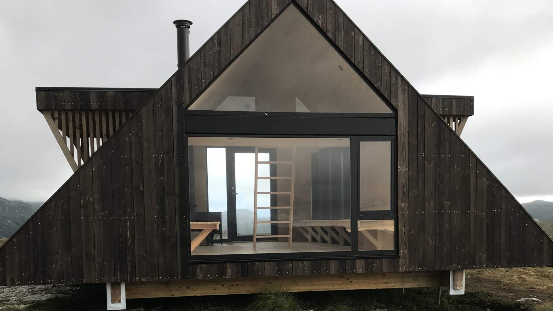 Dagsturhytta er innreidd med benker og vedovn - og store vindusflater