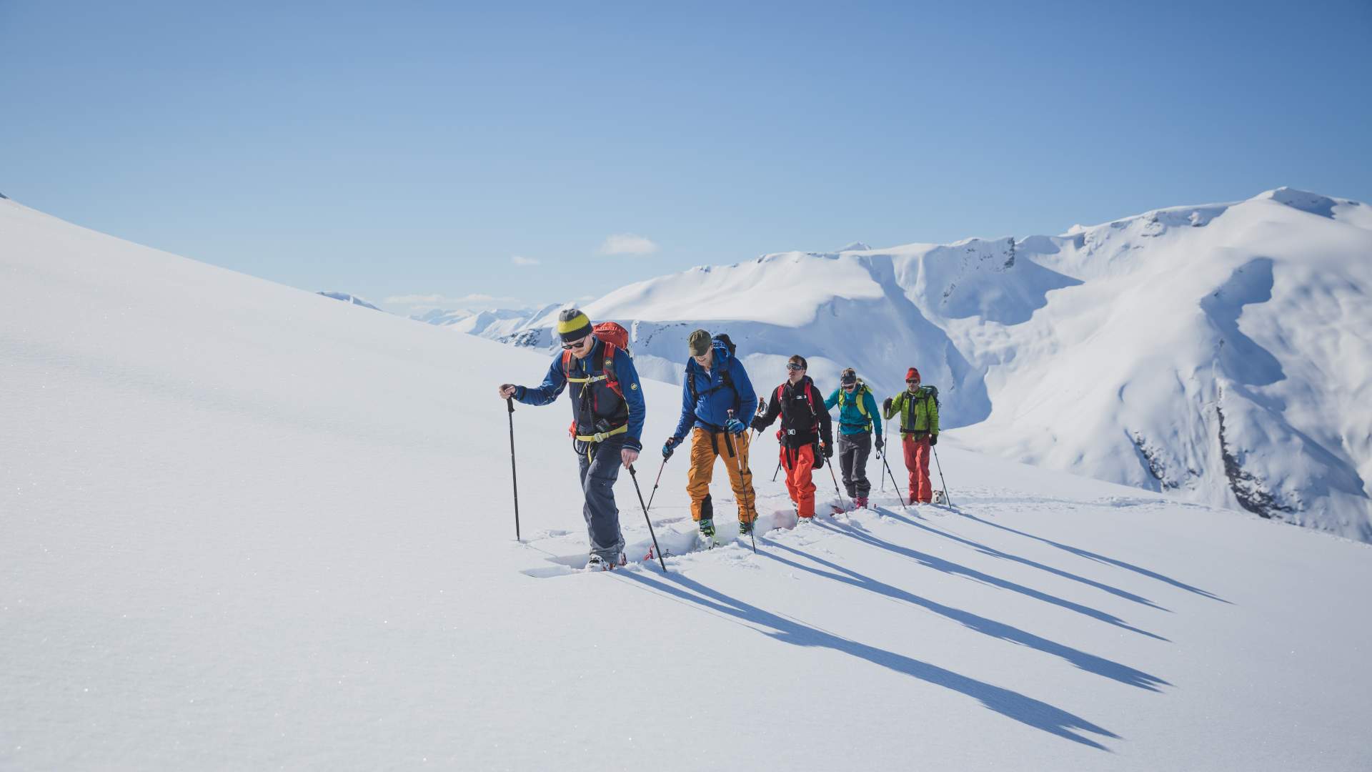 Gruppe på topptur med ski i flotte omgivelser.
