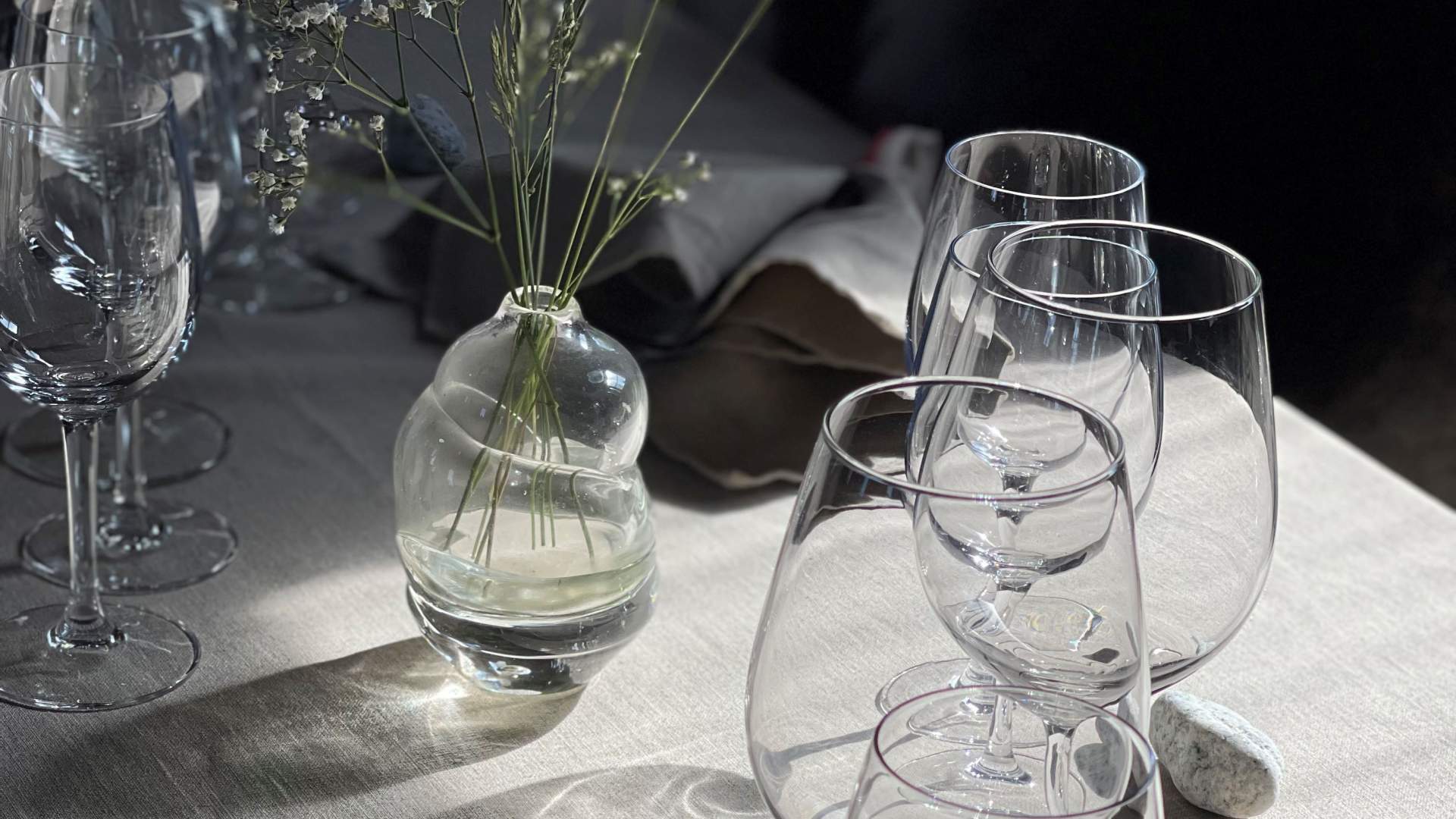 Dekket til fest med fine blomster og glass.