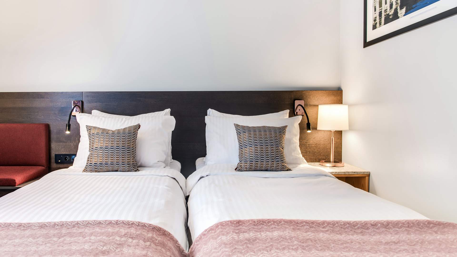 Komfortable senger på hotellrommet.