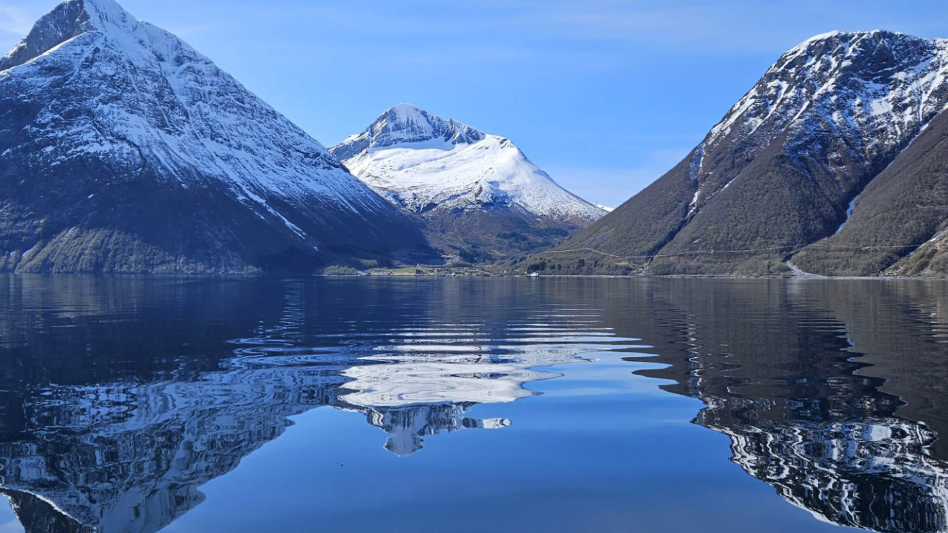 Fra båten ser man inn til vakre Hjørundfjord omkranset av høye fjell.