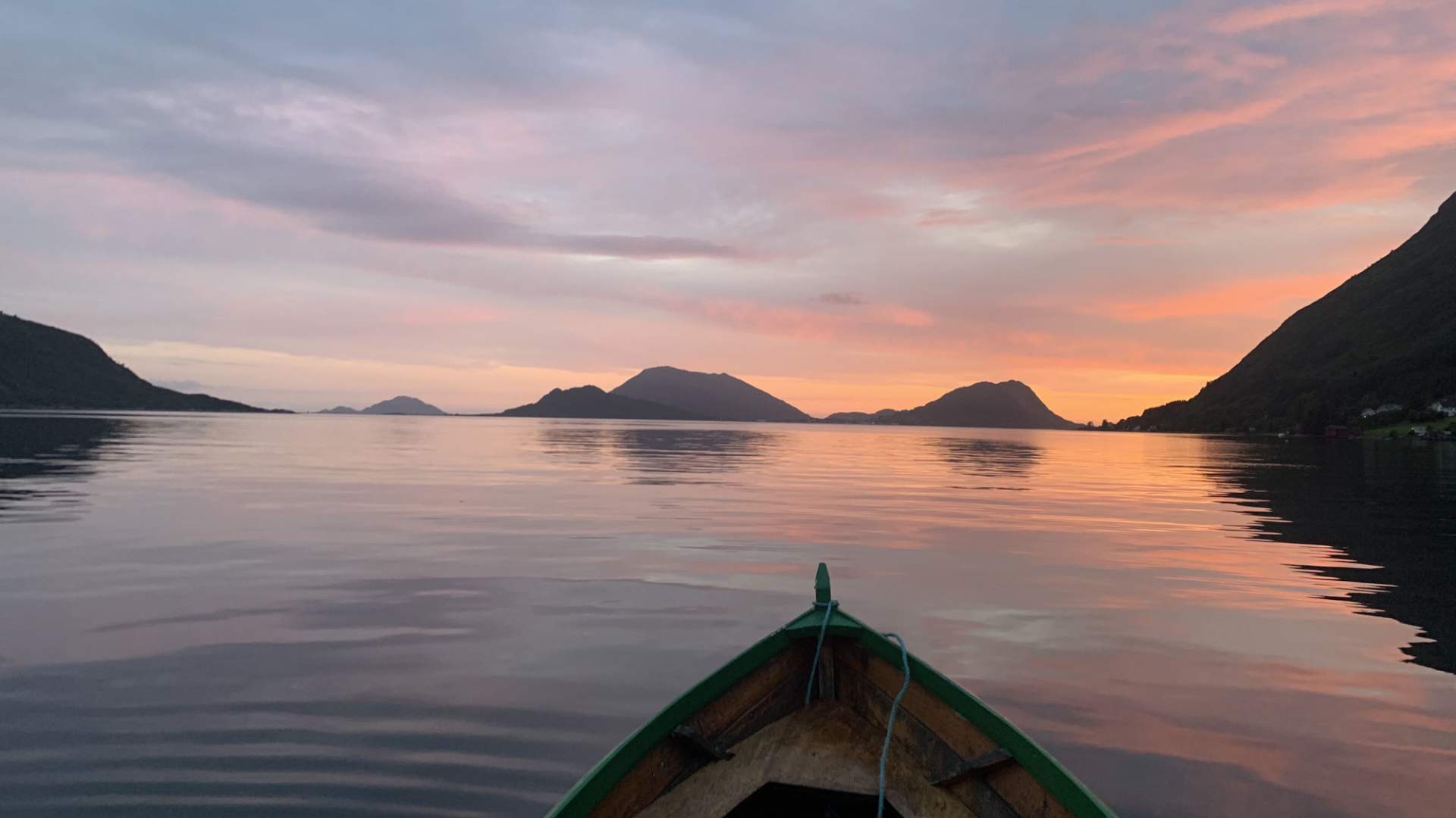 Robåt i solnedgang ut mot havet.