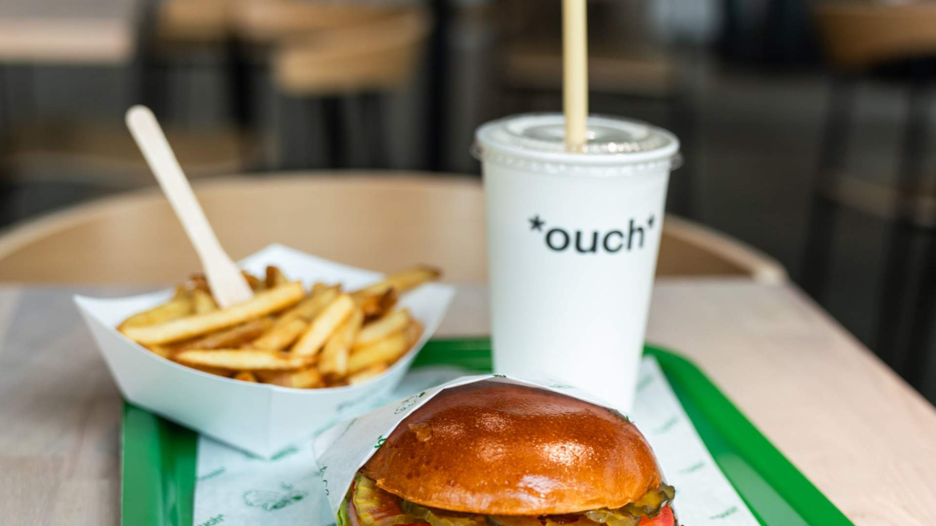 Fries, burger and a drink on a plate on table in restaurant