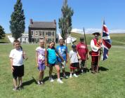 Children practice military drills at Fort Ontario State Historic Site in a unique program coordinated by Oswego County AmeriCorps members Ian Mumpton (right) and Steven Woods.