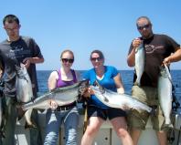 Loyal customers Bobby and Kelsey Ostman (left) and Jessica and Zach Leclair return to Oswego County year after year to fish Lake Ontario for king salmon with Capt. Ed Monette of Cannonball Runner Charters, Oswego. King salmon dominated the Lake Ontario catch in the summer of 2012, according to the New York State Department of Environmental Conservation. (Photo courtesy of Capt. Ed Monette.)