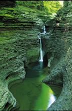 At Watkins Glen State Park, the glen’s stream plunges over 200-foot cliffs, generating 19 waterfalls. The gorge path winds over and under waterfalls, to the spray of Cavern Cascade. (Darren McGee/NYS DED)