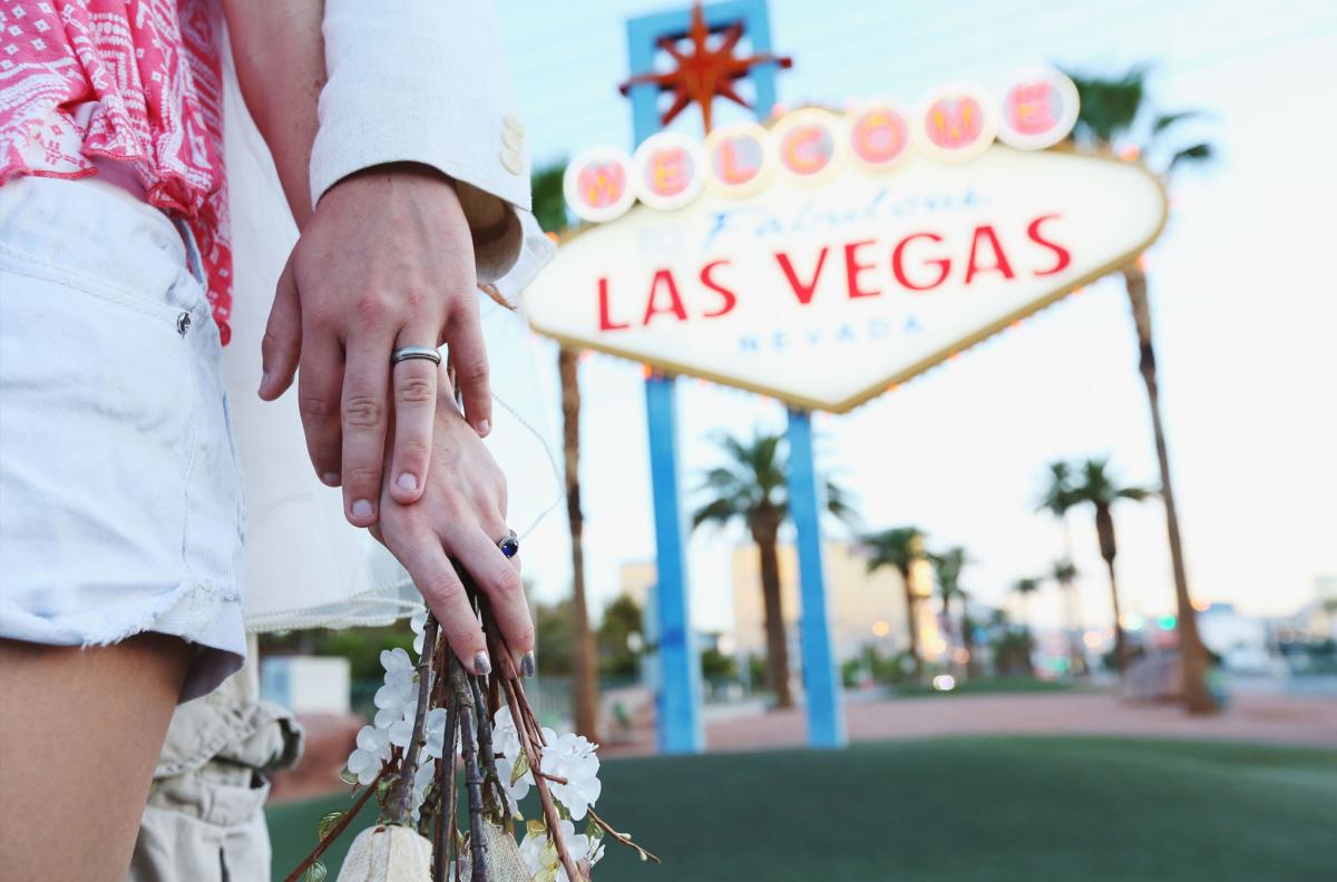Married Couple Holding Hands in Front of the Las Vegas Sign