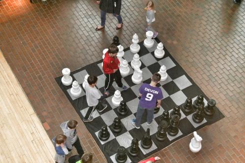 Kids playing on life size chessboard at the Grand Rapids Public Museum