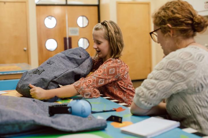 Family opening the Grand Rapids Children's Museum Sensory Friendly Tool Kit bag