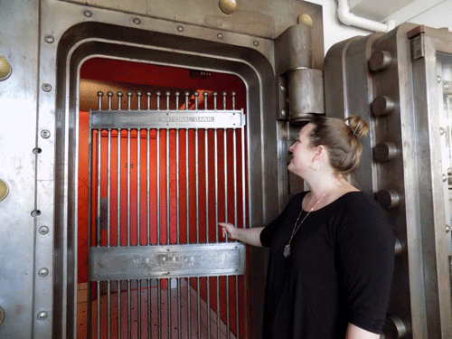 Owner Emily Peterson closes the gate on the vault (which now leads to the restrooms) where Merchants Pub & Plate found their name.