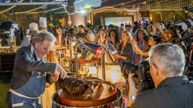 Bryan Cranston cuts into meat at The Feast at Wynn Revelry by Chef's Table