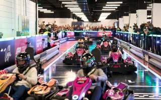 Go karts racing around indoor track in promotion of F1 Las Vegas