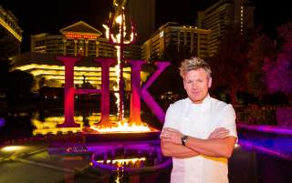 The infamous Gordon Ramsay standing in front of the world-famous Hell's Kitchen sign right by Caesars Palace.