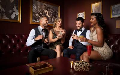 A group of people enjoying themselves with a drink at The Underground Speakeasy inside of the Mob Museum.