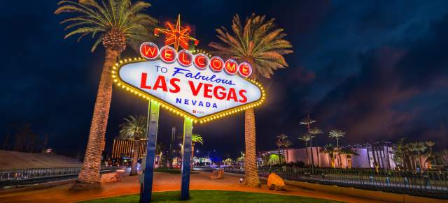 The iconic Welcome to Fabulous Las Vegas sign glowing against the night sky.