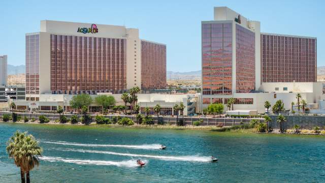 The exterior of Aquarius Casino Resort in Laughlin with jet skiers on the water.