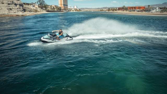 Person having fun on a jet ski ride in the Colorado River in Laughlin, Nevada with casinos in the background.