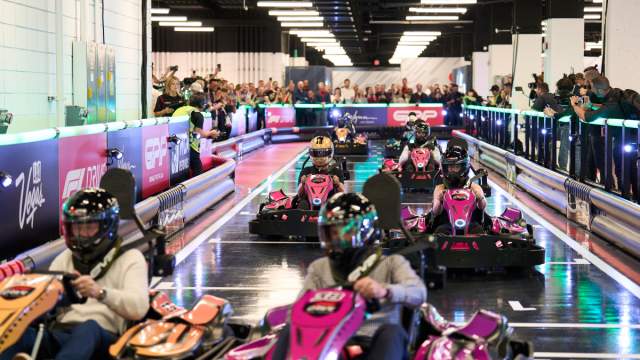 Go karts racing around indoor track in promotion of F1 Las Vegas