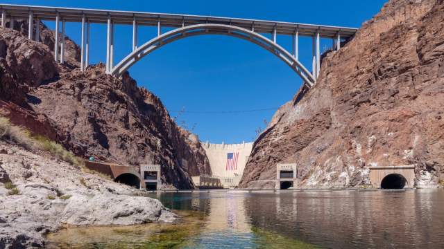 Hoover Dam and Memorial Bridge with giant American flag reflected in the Colorado River near Las Vegas during America 250 celebration.