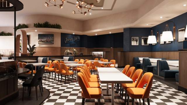 Interior of Jersey Joe's restaurant. Shows seating area with tables and booth with logo featured in background.