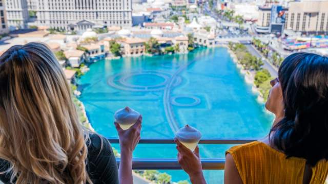 Women Holding Drinks Overlooking Bellagio Fountains Cosmopolitan