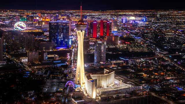A night view of the STRAT Hotel, Casino & Tower and the Las Vegas Strip in the background.