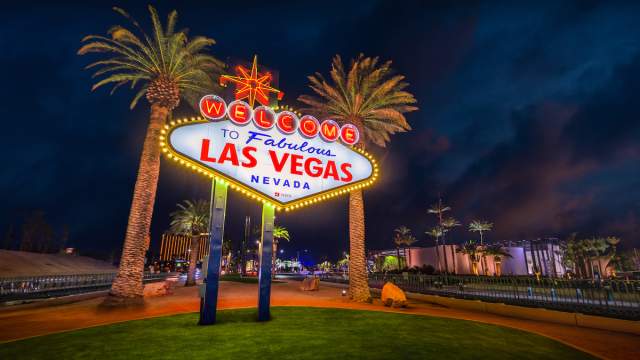 The iconic Welcome to Fabulous Las Vegas sign glowing against the night sky.