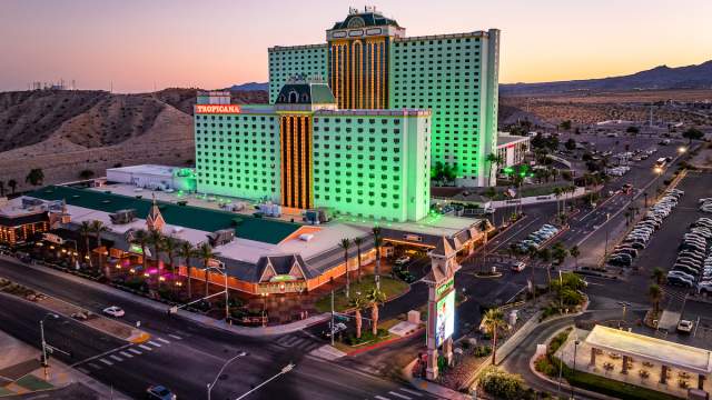 An aerial view of Tropicana Laughlin resort a dusk with the mountain range in the background.