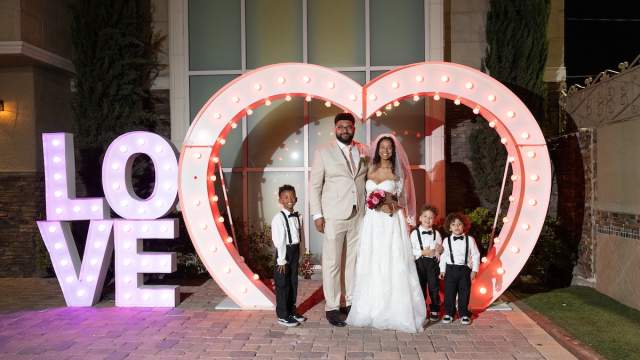 Newly wed couple posing in front of the iconic LOVE sign at Chapel of the Flowers