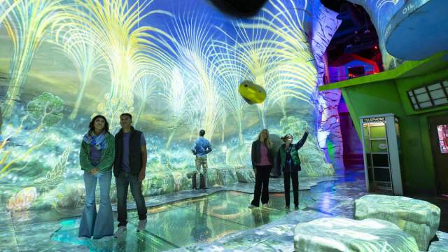 A group of visitors enjoying the stunning visual art in Meow Wolf's Omega Mart at AREA15.