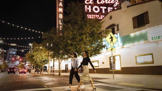 Two girls, hand in hand, walking in downtown Las Vegas.