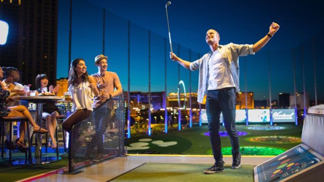 A man basking in the glory of a great swing at TopGolf at MGM Grand in Las Vegas.