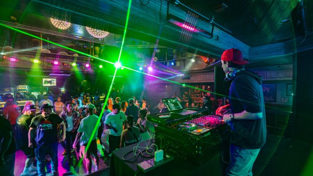 A group of people dancing in front of a DJ at Losers' Lounge at Don Laughlin's Riverside Casino & Resort.