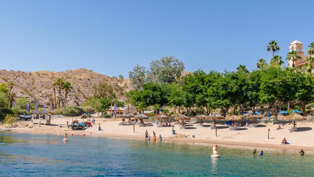 A stunning view of the beach at Harrah's Laughlin with guests enjoying the water.