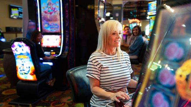 A woman having a great time playing slots at Tropicana Laughlin Hotel and Casino in Laughlin, Nevada!