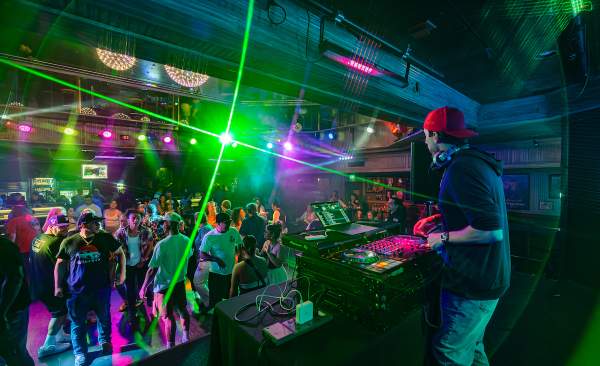 A group of people dancing in front of a DJ at Losers' Lounge at Don Laughlin's Riverside Casino & Resort.