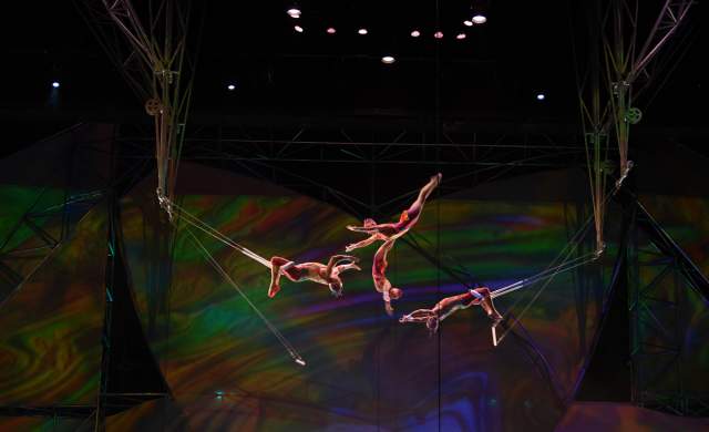 A group of performers doing trapeze on stage during the Mystere show by Cirque du Soleil.