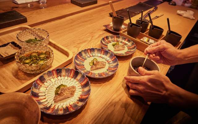 Chef prepping seafood appetizers table side at a restaurant at ITO at Fontainebleau Las Vegas.