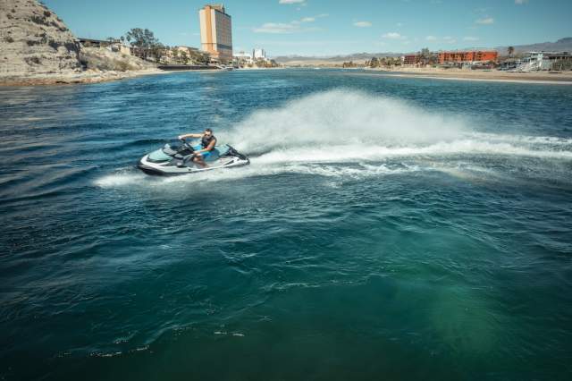 Person having fun on a jet ski ride in the Colorado River in Laughlin, Nevada with casinos in the background.